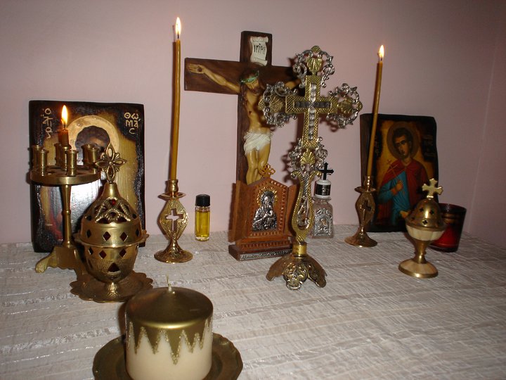 An Orthodox home altar with icons, a cross, and an incense burner.