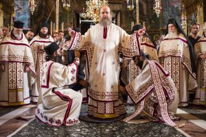 Orthodox bishop being vested by ordained deacons